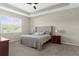 Serene main bedroom featuring a tray ceiling, neutral colors, and plush carpet at 11432 Leland Groves Dr, Riverview, FL 33579