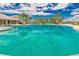 Beautiful community pool surrounded by palm trees, lounge chairs and blue skies at 11432 Leland Groves Dr, Riverview, FL 33579