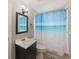 Fresh bathroom with a modern vanity, stylish lighting, and beach-themed shower curtain at 1223 Union St, Clearwater, FL 33755