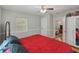 Bedroom with a red bed, light walls, and wooden floors, offering a view into the home at 1223 Union St, Clearwater, FL 33755