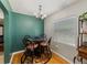 Charming dining room with an ornate light fixture, round table, and a green accent wall at 1223 Union St, Clearwater, FL 33755