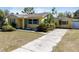 Quaint yellow house with vibrant blue shutters, a cozy exterior with well-maintained lawn at 1223 Union St, Clearwater, FL 33755