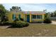 Charming home featuring a bright yellow exterior, blue door, and matching shutters at 1223 Union St, Clearwater, FL 33755