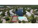 Scenic aerial view of community featuring pool, tennis court, and lush landscaping at 1337 Pine Ridge E Cir # D2, Tarpon Springs, FL 34688