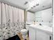 Cozy bathroom featuring a floral shower curtain, white vanity, and toilet at 1337 Pine Ridge E Cir # D2, Tarpon Springs, FL 34688