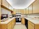 A functional kitchen with light wood cabinets, white appliances, and ample counter space at 1337 Pine Ridge E Cir # D2, Tarpon Springs, FL 34688