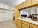 A bright kitchen featuring wood cabinets and a pass-through to the living room at 1337 Pine Ridge E Cir # D2, Tarpon Springs, FL 34688