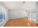 Spacious living room with wood floors, plantation shutters, and a contemporary light fixture at 13625 Dunwoody Ct, Hudson, FL 34667