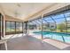 A covered, screened-in pool deck features a pool with clear blue water and plenty of space to relax at 13625 Dunwoody Ct, Hudson, FL 34667