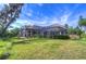 Backyard view showcasing covered patio, and mature trees providing shade and privacy at 16318 Palmettoglen Ct, Lithia, FL 33547