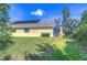 Spacious backyard with solar panels on roof, covered patio, and lush landscaping at 16318 Palmettoglen Ct, Lithia, FL 33547