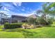 Lush backyard featuring a covered patio area, mature trees, and meticulously manicured landscaping at 16318 Palmettoglen Ct, Lithia, FL 33547