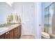 Well-lit bathroom featuring double sinks with granite countertops, wood cabinets, and tile flooring at 16318 Palmettoglen Ct, Lithia, FL 33547