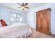 Bedroom featuring a white bedspread, window with blinds, large wardrobe, and a ceiling fan at 16318 Palmettoglen Ct, Lithia, FL 33547
