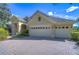 Charming home with a three-car garage, a well-maintained lawn, and a brick driveway for added curb appeal at 16318 Palmettoglen Ct, Lithia, FL 33547
