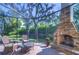 Inviting screened patio area with a cozy stone fireplace and comfortable seating at 16318 Palmettoglen Ct, Lithia, FL 33547