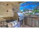 A gourmet stainless steel outdoor kitchen featuring granite countertops and brick accents at 16318 Palmettoglen Ct, Lithia, FL 33547