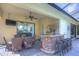 Covered patio boasting an outdoor kitchen with a grill, bar seating, and a dining table at 16318 Palmettoglen Ct, Lithia, FL 33547