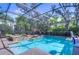 Screened in pool and hot tub area surrounded by mature trees and lush landscaping at 16318 Palmettoglen Ct, Lithia, FL 33547