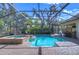 A refreshing backyard swimming pool and hot tub combination nestled in a screened enclosure at 16318 Palmettoglen Ct, Lithia, FL 33547