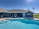 Backyard oasis featuring a sparkling pool with steps and patio furniture on the brick patio at 17703 Country Squire Ln, Dade City, FL 33523