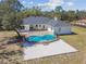 A bright, in-ground pool is fenced in on this aerial view of a home with a large backyard at 18214 Ozark Dr, Hudson, FL 34667