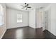 Bedroom features wood floor, a ceiling fan, and natural light at 18214 Ozark Dr, Hudson, FL 34667