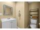 Bathroom featuring a toilet, sink, mirror, towel rack, and cabinet for storage at 18716 Lake Commiston Dr, Lutz, FL 33549