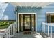 Charming blue home features a decorative glass front door and a front porch at 18716 Lake Commiston Dr, Lutz, FL 33549