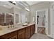 Double vanity in main bathroom with tile flooring, a walk-in shower and walk-in closet at 20118 Heron Crossing Dr, Tampa, FL 33647