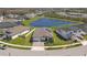 Expansive aerial view of a single-Gathering home with solar panels, a well-manicured lawn, and a tranquil pond at 21396 Snowy Orchid Ter, Land O Lakes, FL 34637