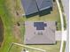Overhead view of a home with solar panels, four skylights, and manicured lawn close to a tranquil lake at 21396 Snowy Orchid Ter, Land O Lakes, FL 34637