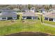 An aerial showcases a green backyard with a patio, perfect for relaxing near the calming waters of a pond at 21396 Snowy Orchid Ter, Land O Lakes, FL 34637