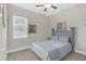 This bedroom features a queen bed with gray headboard, ceiling fan, and a large window for natural light at 21396 Snowy Orchid Ter, Land O Lakes, FL 34637