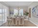 Elegant dining room with table set, large windows providing plenty of natural light and stylish decor at 21396 Snowy Orchid Ter, Land O Lakes, FL 34637