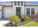 Charming home entrance with a decorative wreath and lush landscaping at 21396 Snowy Orchid Ter, Land O Lakes, FL 34637