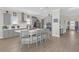 Modern kitchen features gray cabinets, stainless steel appliances, a large island with seating, and wood-look flooring at 21396 Snowy Orchid Ter, Land O Lakes, FL 34637