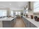 Bright kitchen with gray cabinets, white countertops, stainless steel range hood, and an open design to the dining area at 21396 Snowy Orchid Ter, Land O Lakes, FL 34637