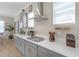 Well-lit kitchen with gray cabinets, white countertops, gas cooktop, and open access to the dining room at 21396 Snowy Orchid Ter, Land O Lakes, FL 34637