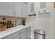 Kitchenette area featuring gray cabinets, light countertops, coffee bar and stainless steel trash receptacle at 21396 Snowy Orchid Ter, Land O Lakes, FL 34637