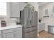Modern kitchen featuring stainless steel refrigerator, light gray cabinets, and white countertops at 21396 Snowy Orchid Ter, Land O Lakes, FL 34637