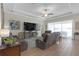 Spacious living room with wood floors, tray ceiling, neutral paint, and comfortable leather sofas at 21396 Snowy Orchid Ter, Land O Lakes, FL 34637