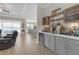 This living room features a custom bar with grey cabinets, wood floors, and neutral paint at 21396 Snowy Orchid Ter, Land O Lakes, FL 34637