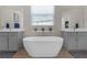 Main bathroom with soaking tub, dual vanity, and wood look floor at 21396 Snowy Orchid Ter, Land O Lakes, FL 34637