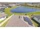 Close aerial shot of a home roof featuring solar panels, set against the backdrop of a serene pond at 21396 Snowy Orchid Ter, Land O Lakes, FL 34637