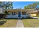 Inviting bungalow with a spacious front porch, decorative railing, and a lovely blue front door at 2222 N Ridgewood Ave, Tampa, FL 33602