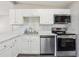 Stylish kitchen featuring white cabinetry, modern appliances, gray backsplash, and bright natural light at 2726 25Th N Ave, St Petersburg, FL 33713