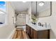 Bathroom with a double vanity, marble-tiled shower, modern fixtures, and wood-look flooring at 2734 17Th N Ave, St Petersburg, FL 33713