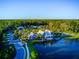 Beautiful aerial view of a lakeside community clubhouse surrounded by lush green trees and landscaping at 4127 Broad Porch Run, Land O Lakes, FL 34638