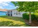 A view of the grassy backyard featuring a screened-in porch with green trees and landscaping at 4127 Broad Porch Run, Land O Lakes, FL 34638